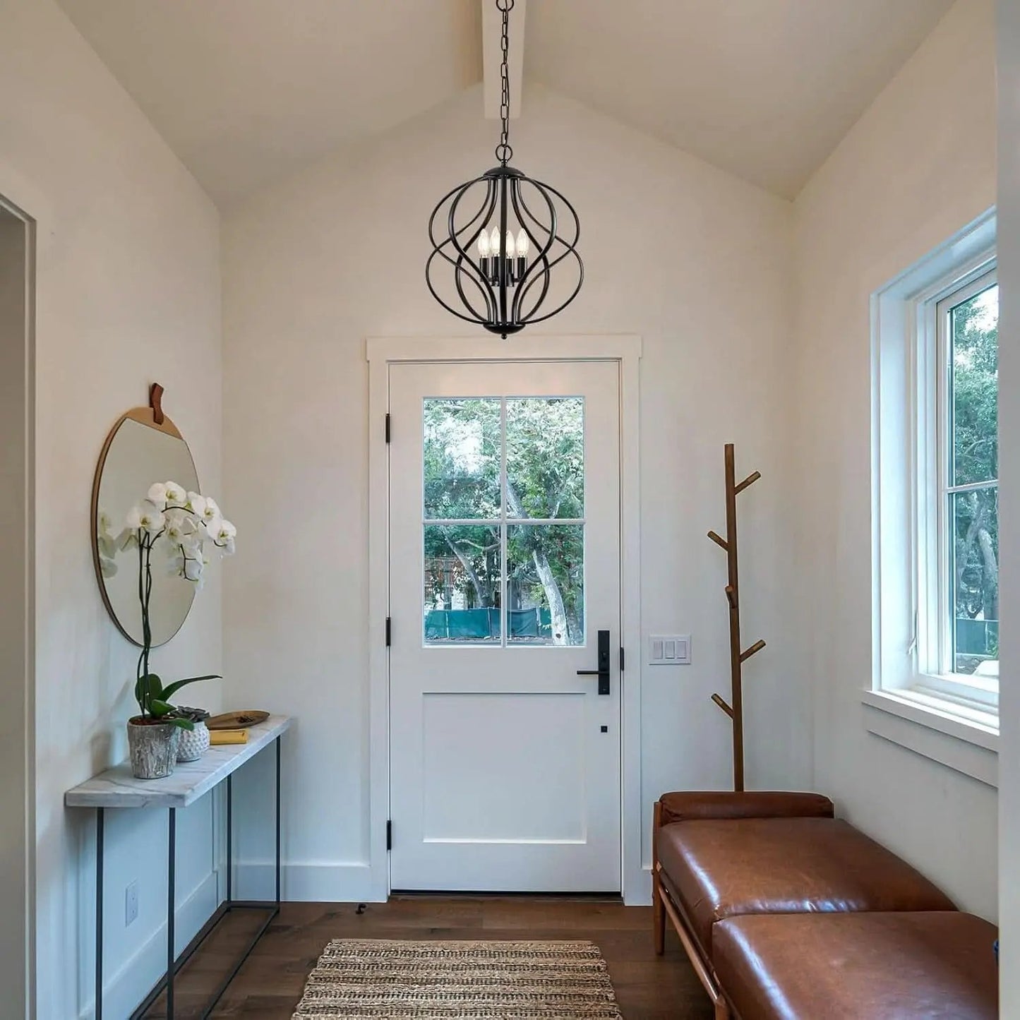 Entryway with a white door, bench, mirror, and coat rack.