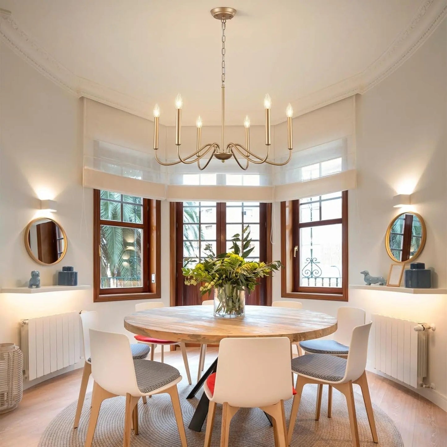 Dining room with round table and chairs, chandelier, and large windows.