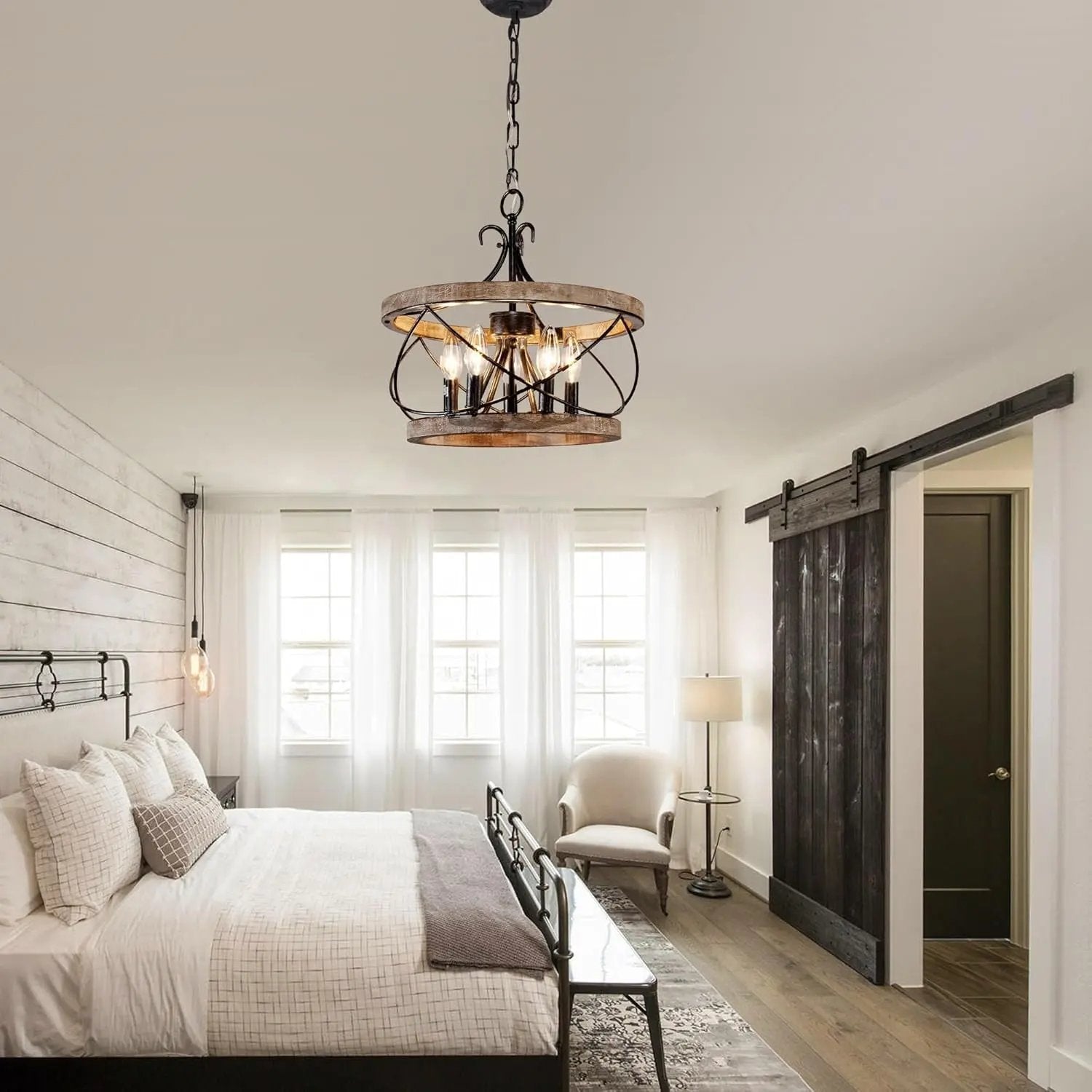 Modern bedroom with a chandelier, bed, and sliding barn door.