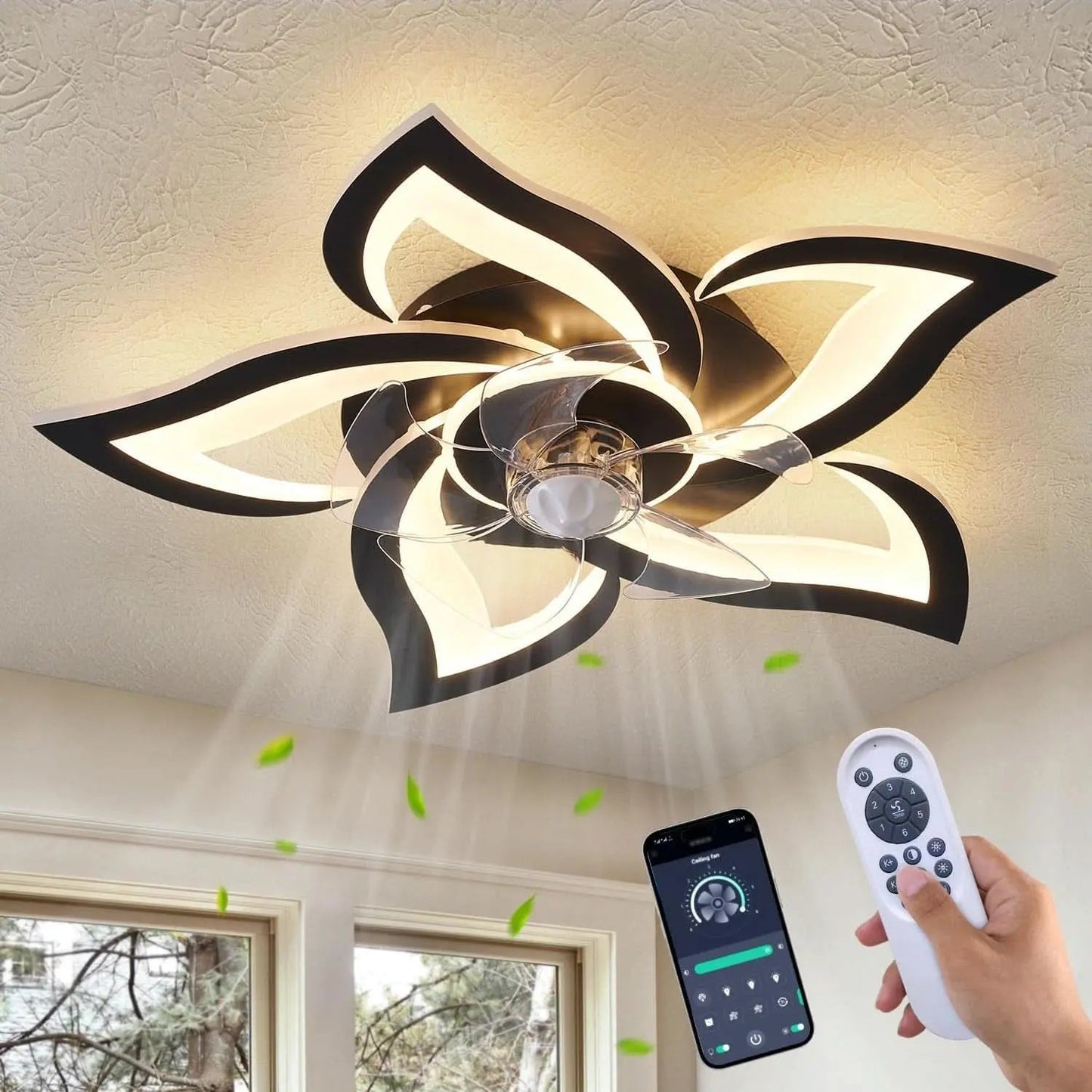 Ceiling fan with black floral design and remote control in a room.