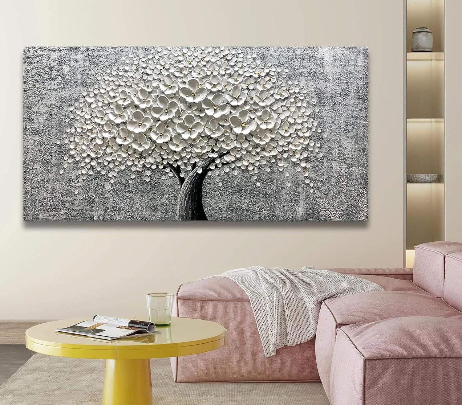 Abstract tree painting on a wall above a pink sofa in a living room.