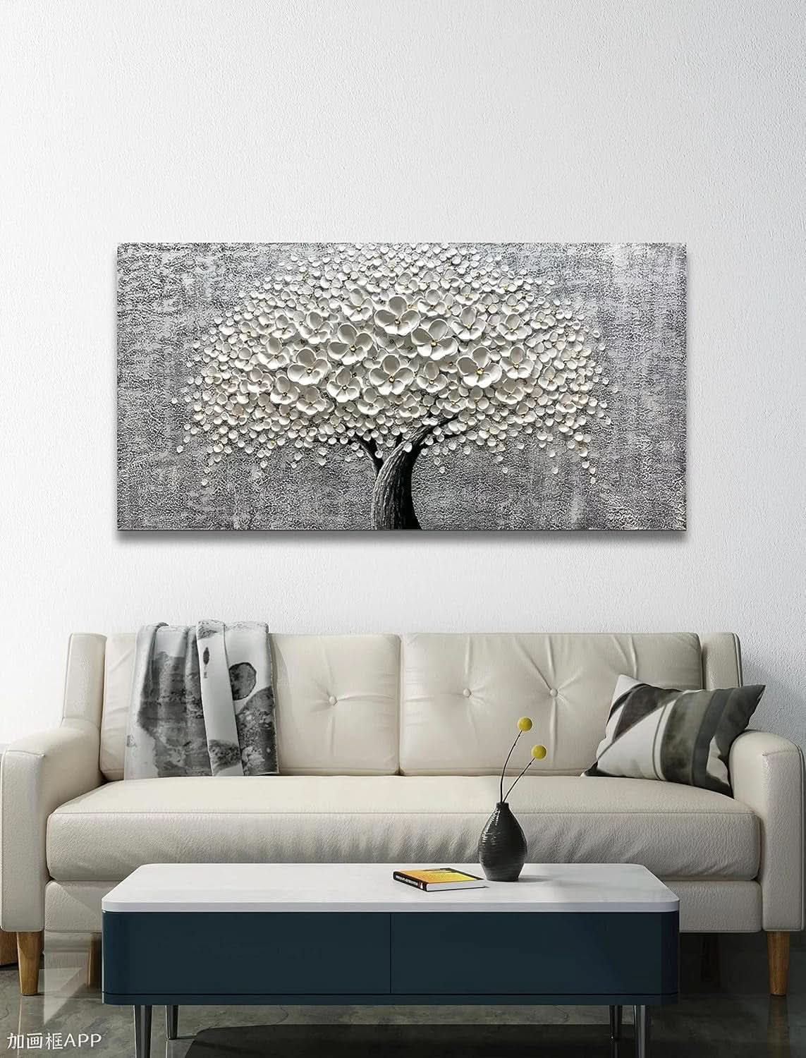 Living room with a large abstract tree painting above a beige sofa.