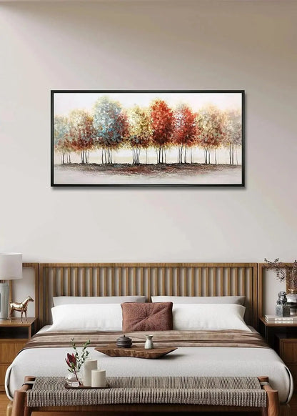 Framed artwork of trees with autumn colors above a bed in a bedroom.