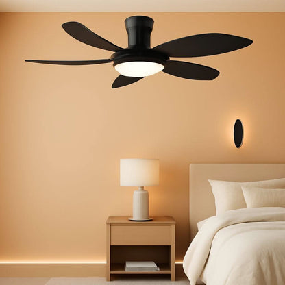 Black ceiling fan mounted on a beige wall above a bed and nightstand.