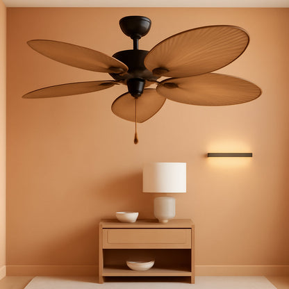 Ceiling fan above a wooden side table with a lamp against an orange wall
