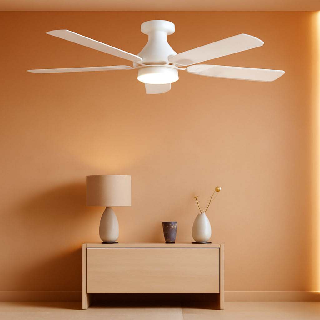 Ceiling fan above a wooden side table with a lamp and decorative items against an orange wall.
