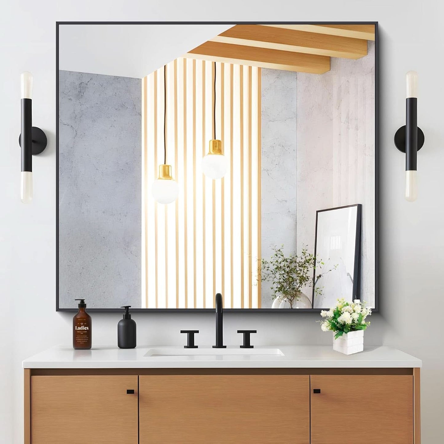 Bathroom vanity with large mirror, lighting fixtures, and decorative elements.