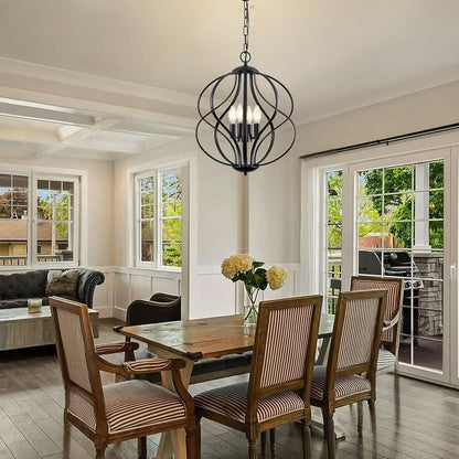 Dining room with wooden table and chairs, black chandelier, and large windows.
