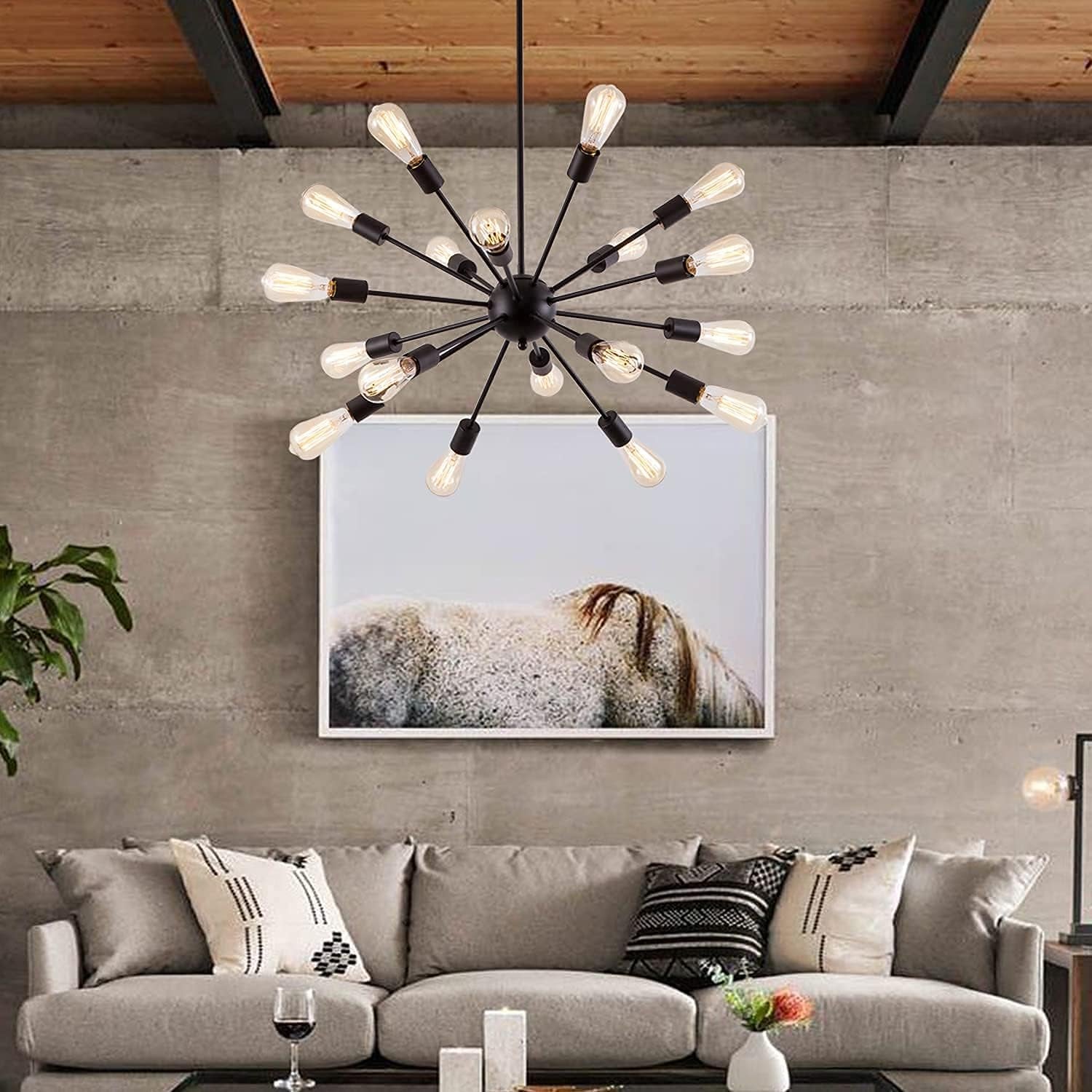 Modern living room with a chandelier, sofa, and wall art.