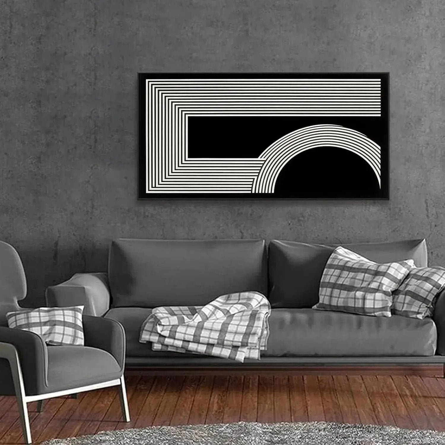 A modern black and white geometric wall art print hanging above a gray sofa in a contemporary living room setting.