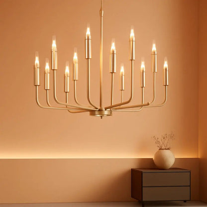 Gold chandelier hanging against an orange wall with a side table and vase.