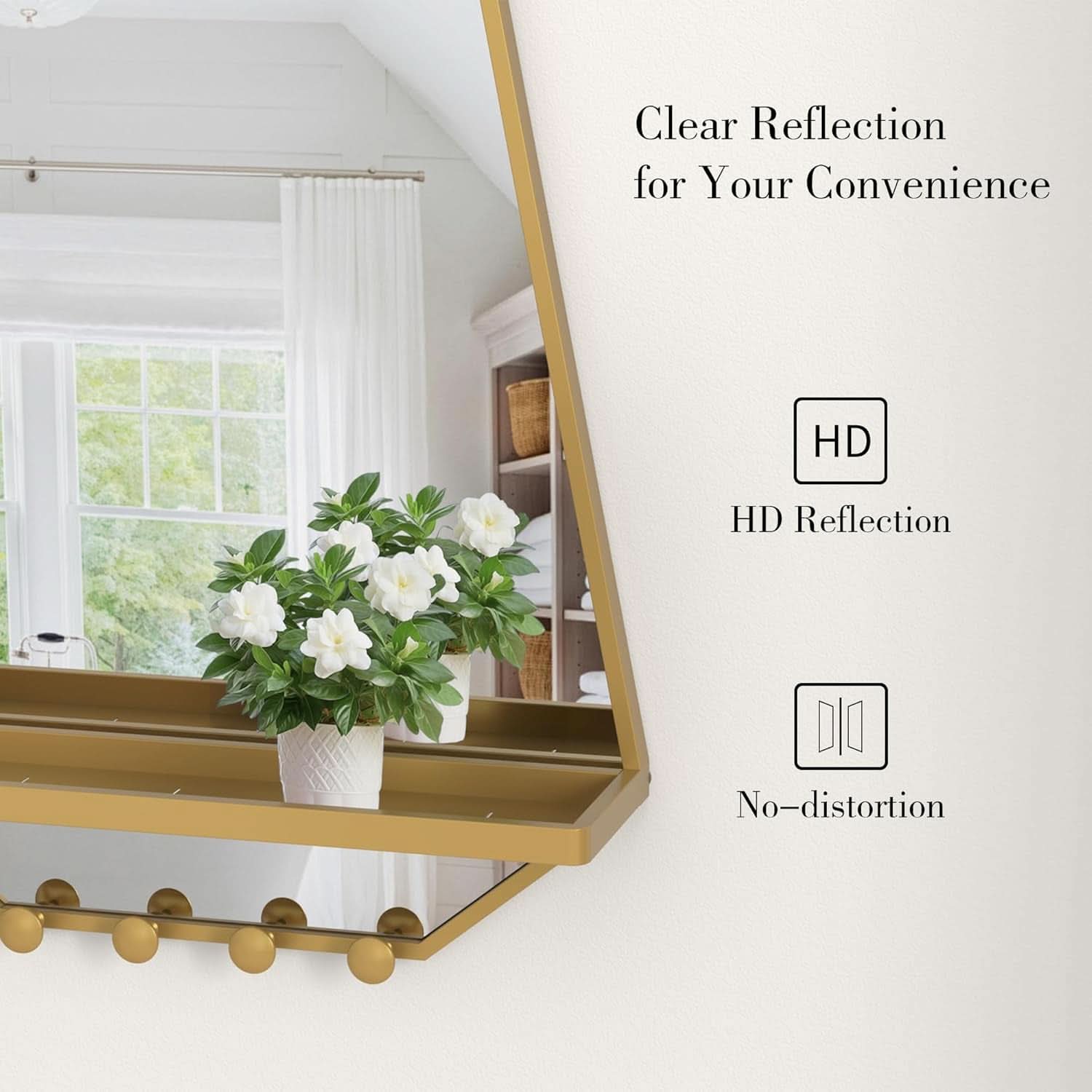 Gold-framed mirror with a clear reflection of a room with white flowers in a vase.