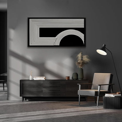 Modern interior with a black and white abstract painting, dark wooden cabinet, and gray armchair.