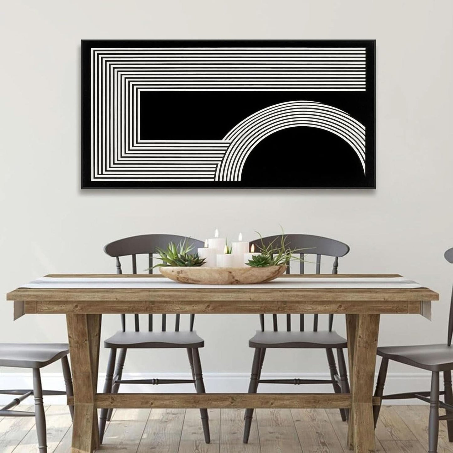 Dining room with a wooden table and chairs, and a black and white abstract art piece on the wall.