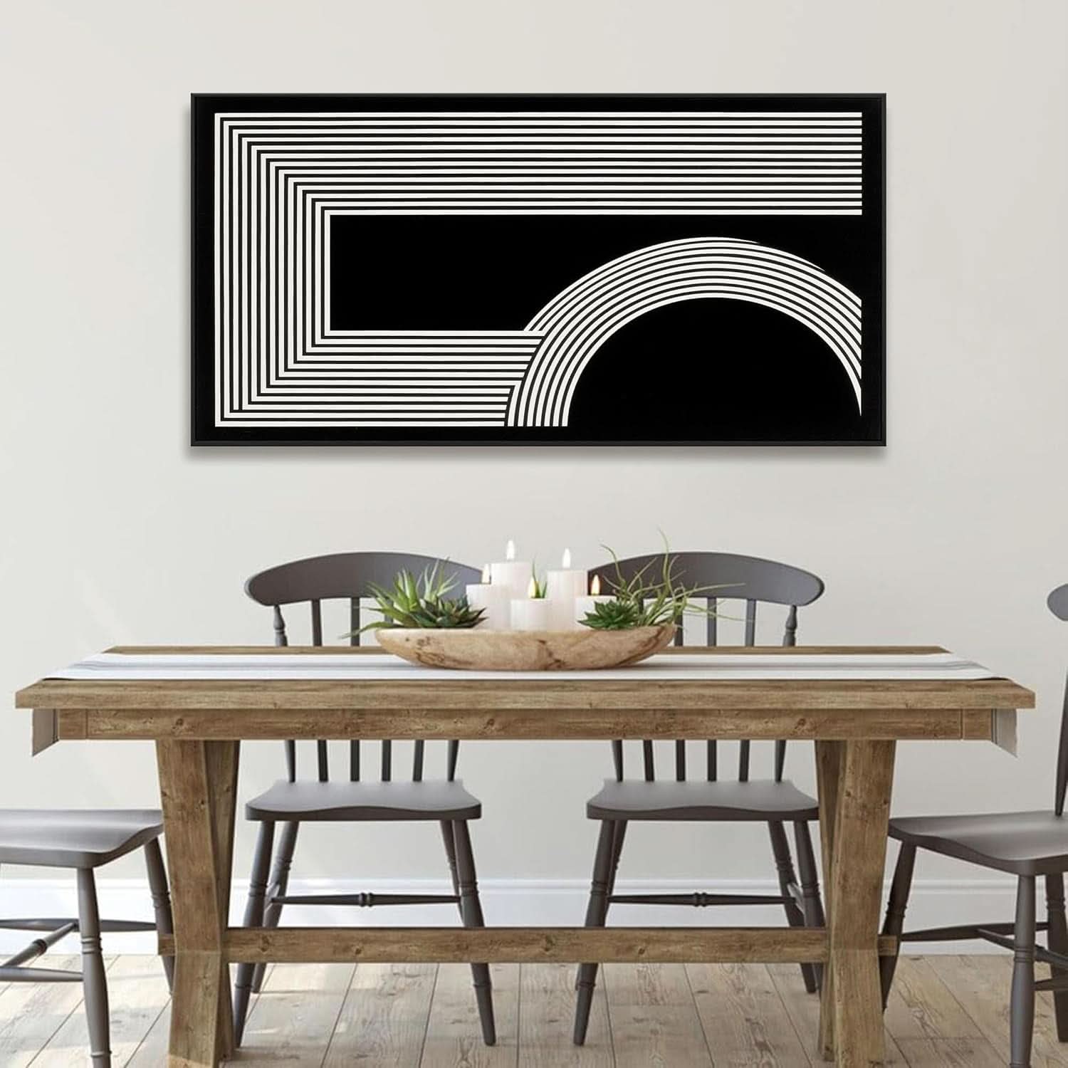 Dining room with a wooden table and chairs, and a black and white abstract art piece on the wall.