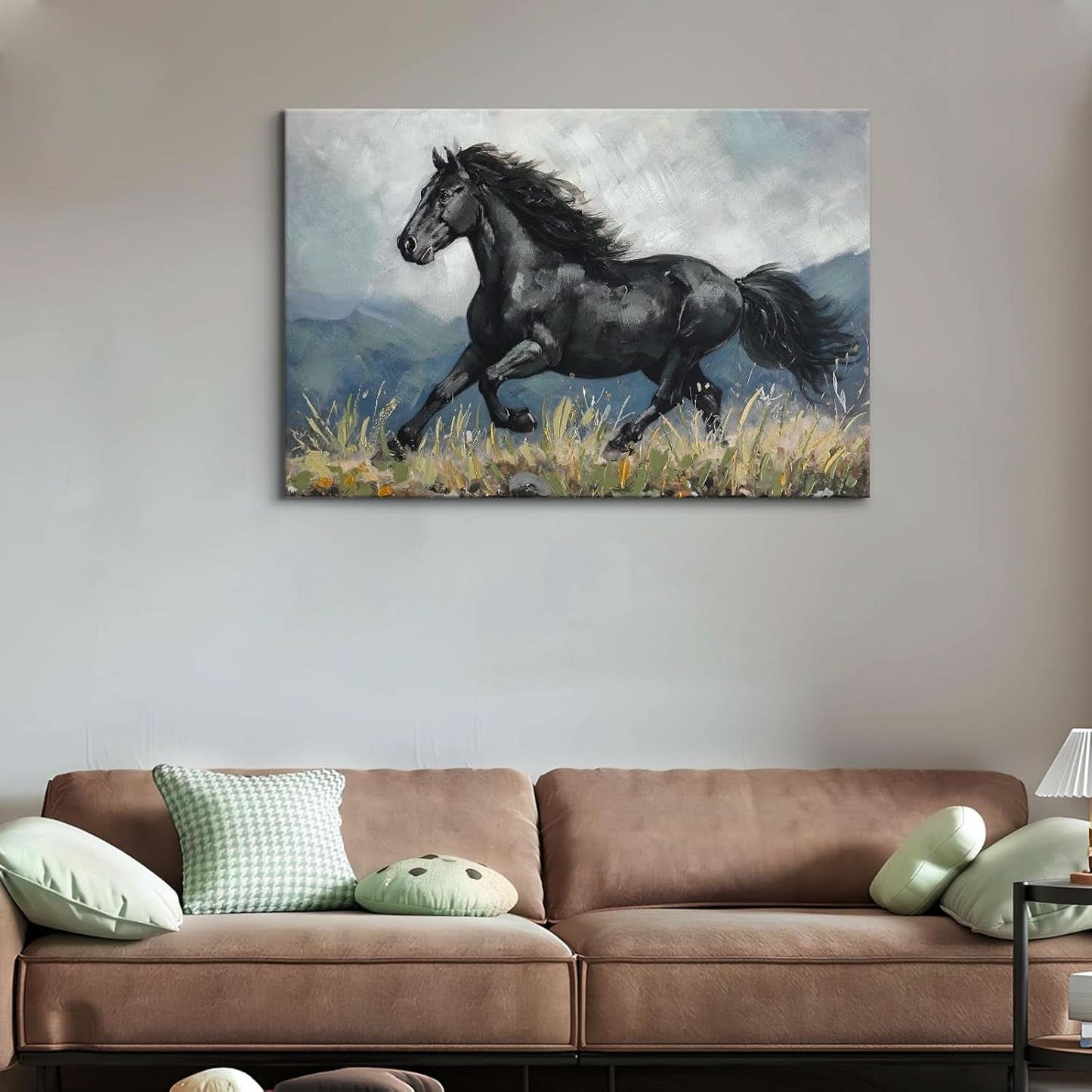 Painting of a black horse running on a wall above a brown sofa with green pillows.