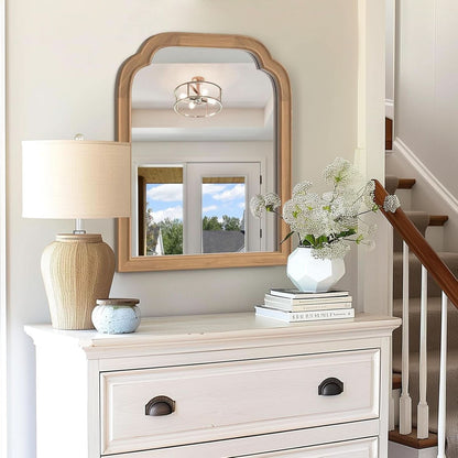 White dresser with mirror, lamp, and decorative items in a home setting