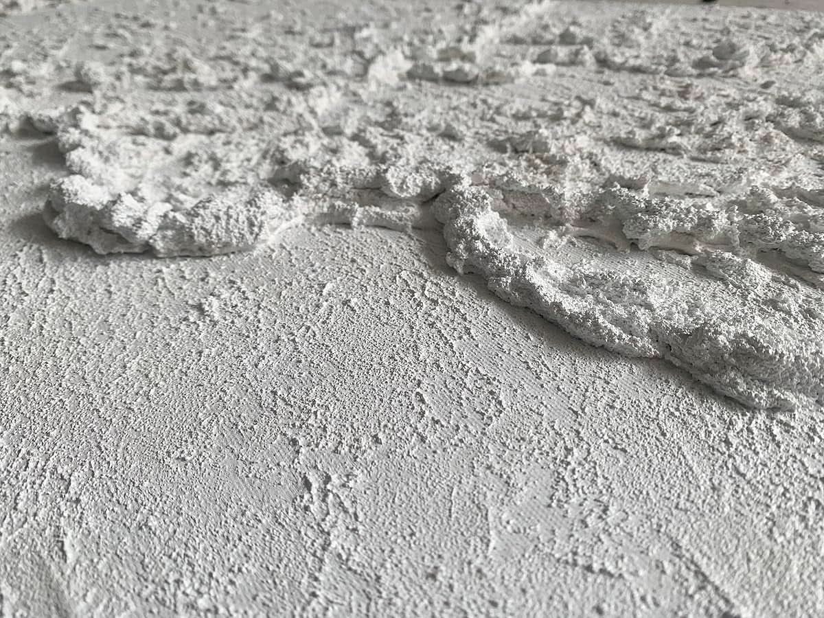 Close-up of textured white surface with cracks and patterns